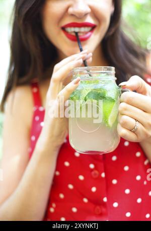 Junge brünette Frau mit einem marmeladenglas in ihrer Hand mit einem Mojito. Sommer trinken Konzept Stockfoto