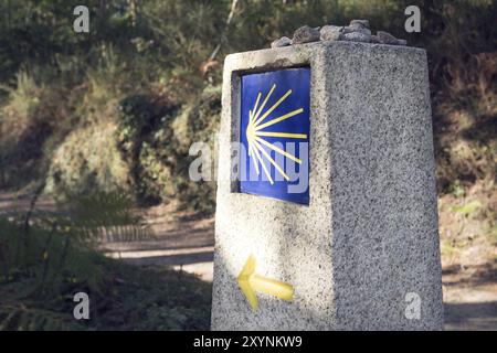 Meilenstein des Jakobsweges mit verschwommenem Weg. Pilgerfahrt nach Santiago de Compostela Stockfoto