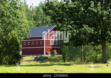 Hofbau eines Bauernhofs in Schweden. Almland im Vordergrund. Nebengebäude einer Farm in Schweden. Auf der Vordergrundweide Stockfoto