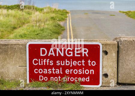 Warnschilder auf der gesperrten Straße zur Küste, die durch Erosion zerstört wurde, zu sehen in Aldbrough, East Riding of Yorkshire, England, Großbritannien Stockfoto