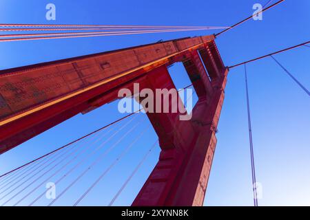 Niedrigen Winkel Closeup Detailansicht der rote Golden Gate Bridge Tower und Kabel vor einem blauen Himmel in der Nähe von San Francisco, Kalifornien Stockfoto