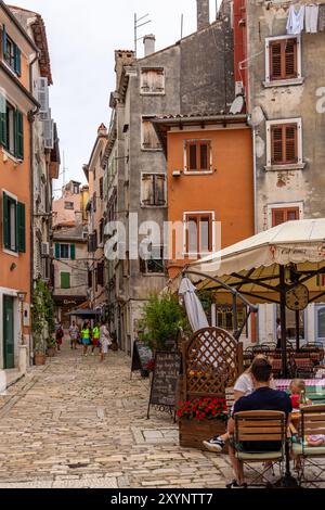 Farbenfrohe, malerische, enge Kopfsteinpflasterstraße in der Altstadt von Rovinj, malerische Häuser mit Fensterläden, Waschmaschine und ein Restaurant, Rovinj, Kroatien. Europa Stockfoto