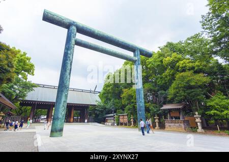 Tokio, Japan, 30. Juli 2015: Menschen gehen durch das angewinkelte Daini Torii Tor, um eine Holztür am Eingang des umstrittenen Yasukuni Shinto-Schreins zu schimmern Stockfoto