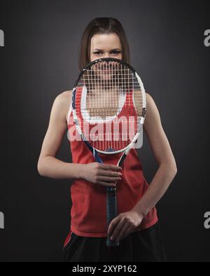 Porträt einer sportlichen Teenager-Tennisspielerin mit Schläger Stockfoto