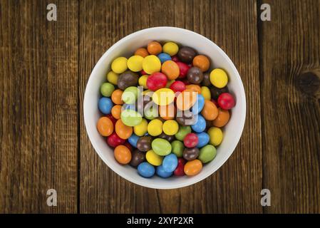 Cocolate beschichtet Erdnüsse auf rustikalen Holzmöbeln Hintergrund (Nahaufnahme) Stockfoto