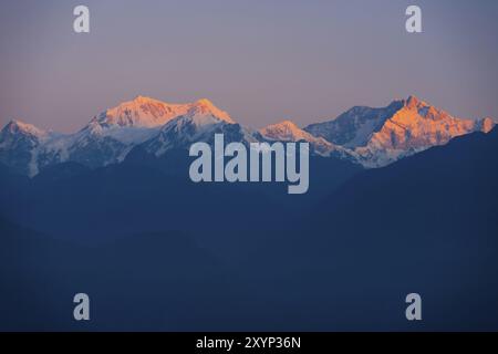 Der Gipfel des Kangchenjunga Berges, der dritthöchste Berg der Welt, leuchtet rot, während er die Farben eines Morgensonnenaufgangs von Darjeeli aus einfängt Stockfoto