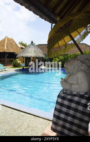 Eine balinesische Statue und ein Schwimmbad in einem Resort in Kuta, Bali, Indonesien, Asien Stockfoto