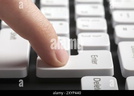 Finger drücken die ENTER-Taste auf der Computertastatur. Seitenansicht Stockfoto
