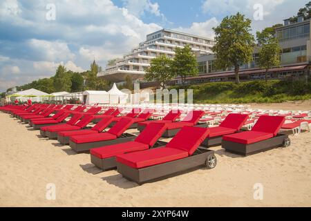 Leere Liegen in einer Reihe am Sandstrand und Hostel Stockfoto