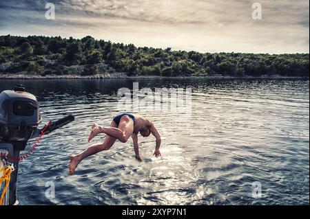 Ein Mann nimmt einen Kopf vom Deck einer Segelyacht Stockfoto