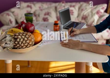 Ernährungsärztin, die wöchentliche Essensplanerin in ihrem Büro macht. Diät, gesunde Ernährung, Abnehmen und Gewichtsverlust Konzept. Stockfoto