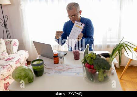 Online. Ernährungswissenschaftler, der wöchentliche Essensplaner in seinem Büro macht. Diät, gesunde Ernährung, Abnehmen und Gewichtsverlust Konzept. Stockfoto