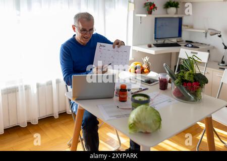 Online. Ernährungswissenschaftler, der wöchentliche Essensplaner in seinem Büro macht. Diät, gesunde Ernährung, Abnehmen und Gewichtsverlust Konzept. Stockfoto