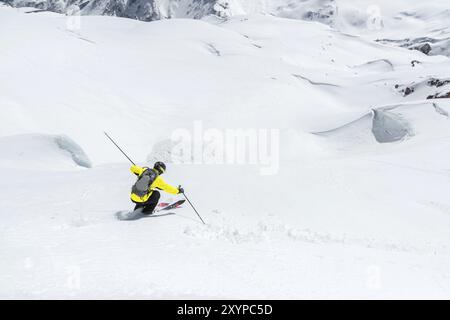 Ein Skifahrer mit Geschwindigkeit fährt auf einer schneebedeckten Piste Freeride. Das Konzept des Winter Extremsports Stockfoto