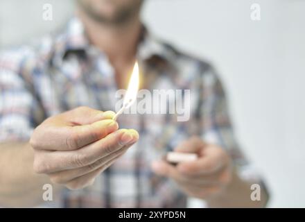 Der Mann zündet ein Feuer mit einem Streichholz an Stockfoto