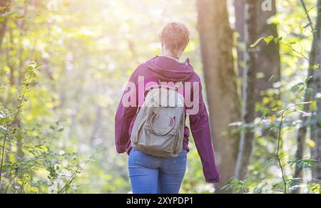 Junge Frau geht im Frühling durch den Wald Stockfoto