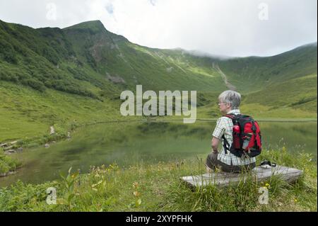 Frau sitzt auf einer Bank am Schlappoldsee Stockfoto