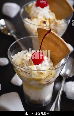 Durian-Eis mit Kirschen und Waffel auf schwarzem Holz Hintergrund Stockfoto