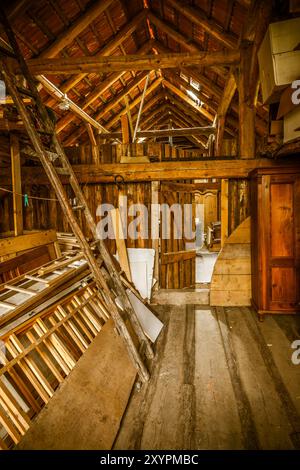 Innenraum eines alten Holzschuppen mit Holzabfällen und Sonnenstrahlen. Alte Scheune Stockfoto