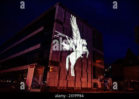 Arnhem, Gelderland, Niederlande. August 2024. Das Symbol der Airborne Division ist an der Wand des Rathauses zu sehen. An die 80. Schlacht von Arnheim erinnert man, in der Abenddämmerung erleuchten spezielle Projektionen Gebäude im Stadtzentrum. Die Schlacht bei Arnheim wurde während der Operation Market Garden ausgetragen. Die Operation Market sollte die deutschen Truppen überraschen und Arnheim und seine wichtigen Brücken über den Rhein erobern, bevor sie von den Verteidigern zerstört werden konnten. Es war der größte Luftangriff in der Geschichte und einer der ehrgeizigsten alliierten Operationen der Zweiten Welt Wa Stockfoto