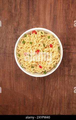 Ein Foto aus einer Schüssel Nudeln mit Red Hot Chili Peppers und kopieren Sie Raum, auf einem dunklen rustikalen Hintergrund Textur Stockfoto