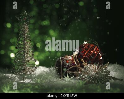 Roter Weihnachtsschmuck und ein glänzender Weihnachtsbaum auf grünem Hintergrund mit fallendem Schnee in stimmungsvollen dunklen Settings. Künstlerische Winterferien, Neujahr con Stockfoto