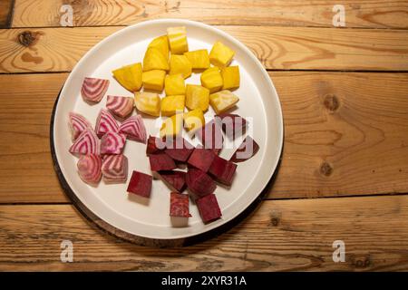 Ein Teller mit zerkleinerten Zutaten, die für eine köstliche Mahlzeit aus frischen gelben, rosa und weißen chioggia-Rüben bereit sind Stockfoto