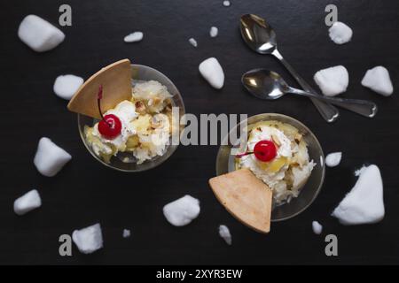 Durian-Eis mit Kirschen und Waffel auf schwarzem Holz Hintergrund Stockfoto