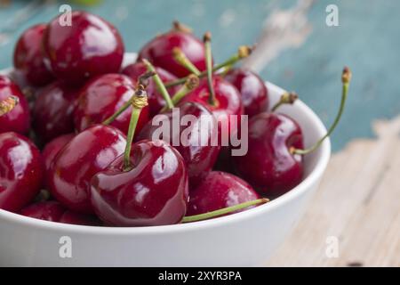 In der Nähe Bild von frischen roten Erdbeeren in einer weißen Schüssel liegend auf einer rustikalen Tisch, im Freien Stockfoto