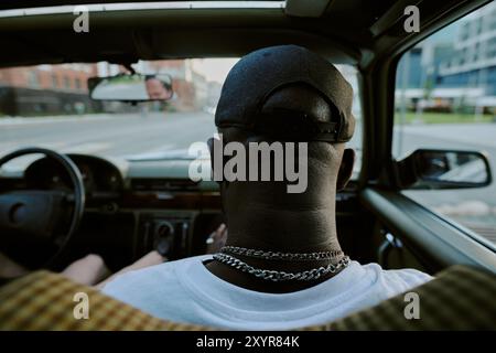 Rückansicht von einem nicht erkennbaren männlichen Hintermann im Auto, Mann sitzt auf dem Vordersitz Stockfoto