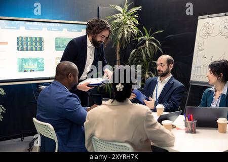 Verschiedene Geschäftskollegen untersuchen Markttrends anhand ihrer Finanzpapiere, untersuchen Budgetierung und Finanzprognosen. Forecast-Partner nehmen an einer Besprechung zur Informationsweitergabe Teil. Stockfoto