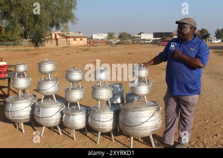 (240830) -- FRANCISTOWN (BOTSWANA), 30. August 2024 (Xinhua) -- Foto vom 13. August 2024 zeigt einen Mann, der Aluminiumtöpfe aus Schrott in Francistown, Botswana, zeigt. Laut der Website des botswanischen Ministeriums für Umwelt und Tourismus stieg die Zahl der Recycling-Organisationen von 80 im Jahr 2017 auf 210 im Jahr 2023, da die Einheimischen durch finanzielle Anreize für den Umgang mit Müll gelockt werden. Als Reaktion auf das gestiegene Angebot an Kunststoffabfällen, die auf den Verkauf warten, und die Möglichkeit, neue Rohstoffe aus kostengünstigen Materialien zu verkaufen, haben sich auch Kunststoffrecyclingunternehmen, die die Abfälle kaufen und verarbeiten, verpflichtet Stockfoto