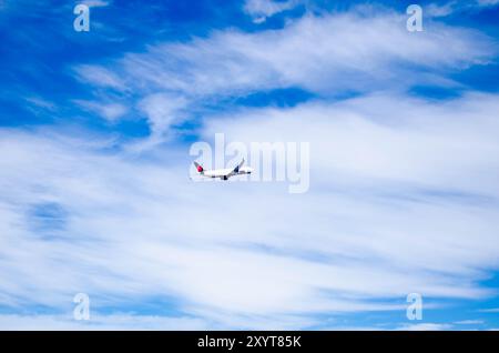 Flugzeug Fliegen gegen einen klaren blauen Himmel – Luftfahrt und Reisekonzept Stockfoto
