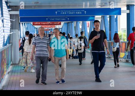Hongkong, China - 03. Juli 2024 : Fußgänger auf einer Fußgängerbrücke in Hongkong, China. Stockfoto