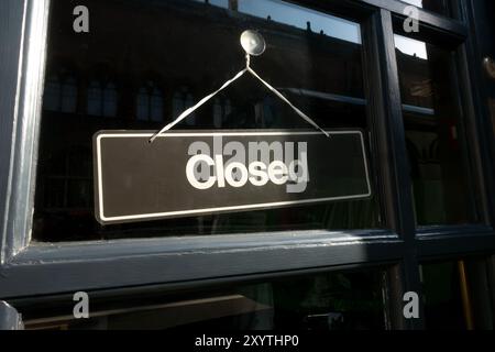 Geschlossenes Schild in der Glastür eines kleinen Unternehmens, das eine wirtschaftliche Rezession anzeigt Stockfoto