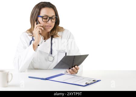 Ärztin bei der Arbeit betrachten eine Röntgenaufnahme, isoliert in weiß Stockfoto