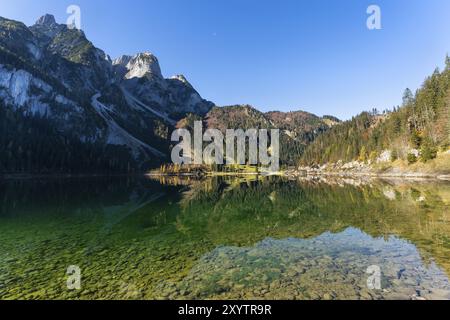 Der vordere Gosausee im Herbst mit Blick auf den Gasthof Gosausee. Der Gosaukamm links, gutes Wetter, blauer Himmel. Reflexion. Vorderer Gosausee, Stockfoto