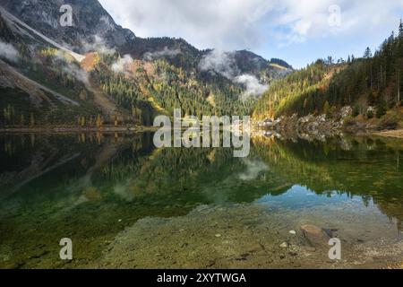 Der vordere Gosausee im Herbst mit Blick auf den Gasthof Gosausee. Sonne und Wolken. Reflexion. Vorderer Gosausee, Gosau, Gosautal, Salzkammergut, Stockfoto