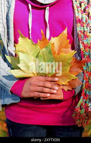 Junge Frau mit Herbstlaub in der Hand, Hannover, Niedersachsen Stockfoto