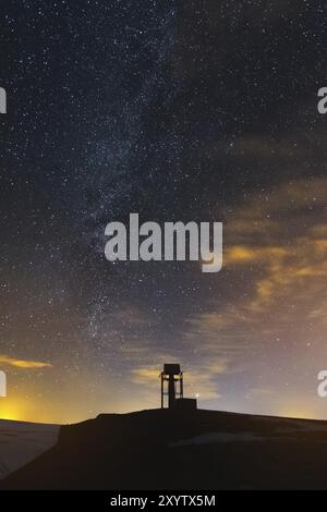 Nachtlandschaft im Kaukasus. Sternenhimmel und Milchstraße mit einem meteorologischen Turm auf dem Plateau Stockfoto