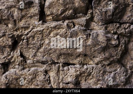 Schließen Sie große Steine in mittelalterlichem Mauerwerk strukturierter Hintergrund einer Mauer aus mittelalterlichem Mauerwerk. Die Mauer ist schlampig und aus Bergsteinen gebaut. Mediev Stockfoto