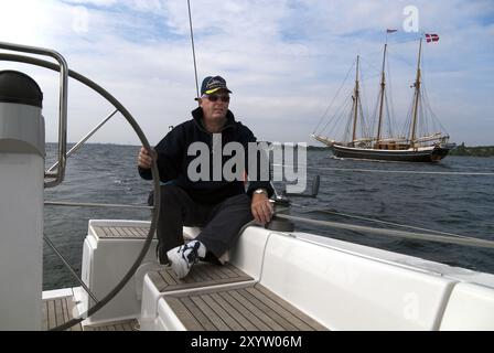 Der Kapitän sitzt am Steuer einer Segelyacht Stockfoto