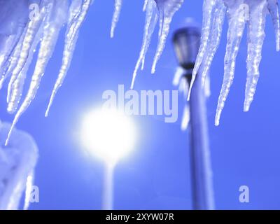 Eiszapfen beleuchtet von einem Licht einer Straßenlaterne gegen blauen Dämmerhimmel. Niagarafälle, Ontario, Kanada, Nordamerika Stockfoto