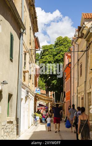 Kroatien, 21 07 2014: Eine schmale Fußgängerstraße der alten touristischen Stadt, die Leute vorbeilaufen. Reiseziel an der kroatischen Mittelmeerküste, Europa Stockfoto