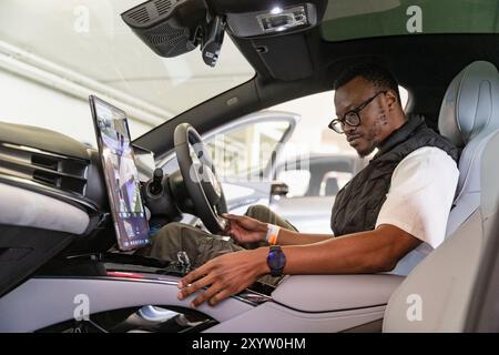 Johannesburg, Südafrika. 30. August 2024. Ein Besucher probiert ein Elektrofahrzeug von BYD aus China während des Festivals of Motoring in Johannesburg, Südafrika, 30. August 2024. Diese Veranstaltung findet hier vom 30. August bis zum 1. September statt. Quelle: Zhang Yudong/Xinhua/Alamy Live News Stockfoto