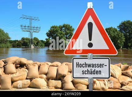 Sandsäcke und ein Warnschild am Elbufer während des Hochwassers in Magdeburg Stockfoto