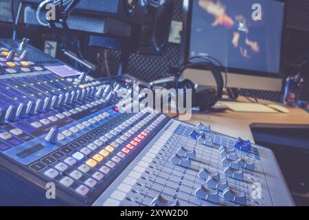 Professionelle Musikproduktion in einem Tonstudio, Mischpult und Equipment im verschwommenen Hintergrund Stockfoto