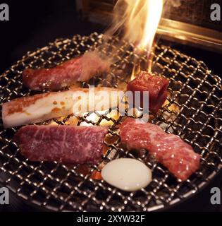 Fleisch auf dem Grill wird in einem japanischen Grillrestaurant auf dem Feuer gekocht. Yakiniku, japanisches Barbecue Stockfoto