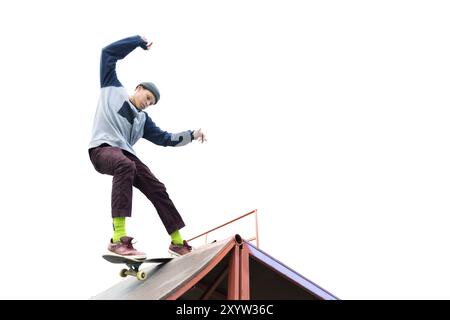 Teenager Skater in Hoodie Sweatshirt und Jeans gleiten über eine Rampe auf einem Skateboard isoliert auf weiß Stockfoto