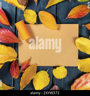 Herbstvorlage mit Weinkork auf braunem Kraftpapier mit leuchtenden Herbstblättern, die einen Rahmen für Text und Logo bilden, auf einem dunklen, rustikalen Wald Stockfoto